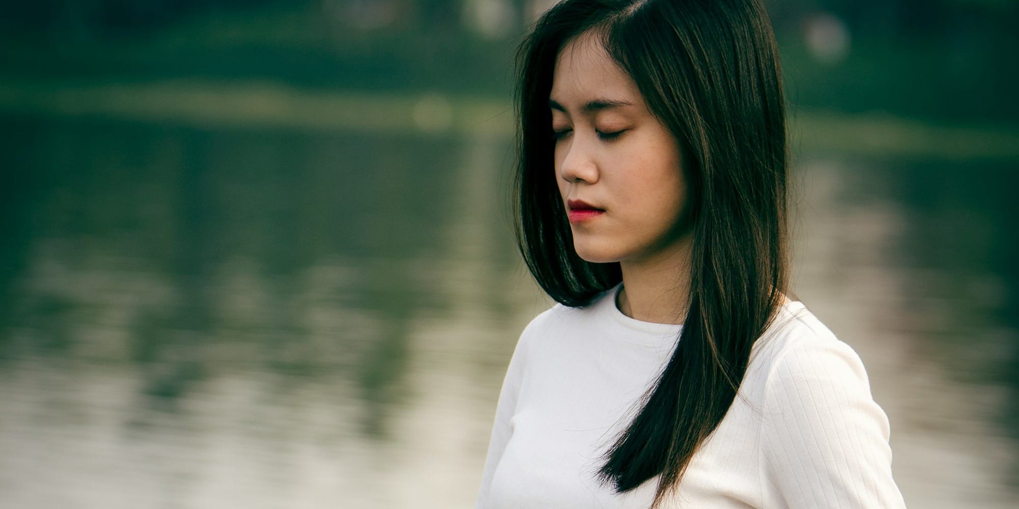 woman meditating on wooden dock during daytime